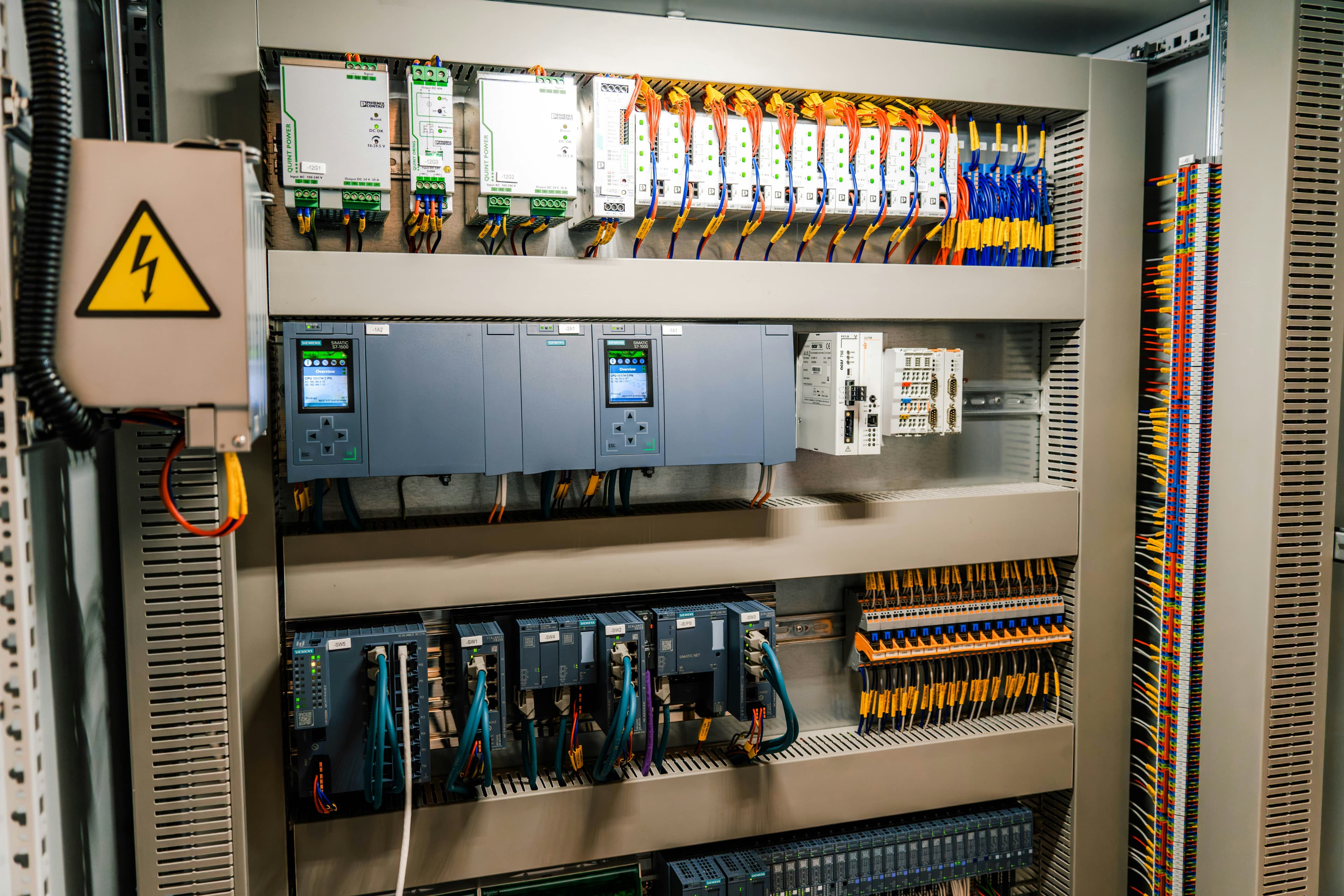 Tablero de control industrial con cableado y módulos electrónicos